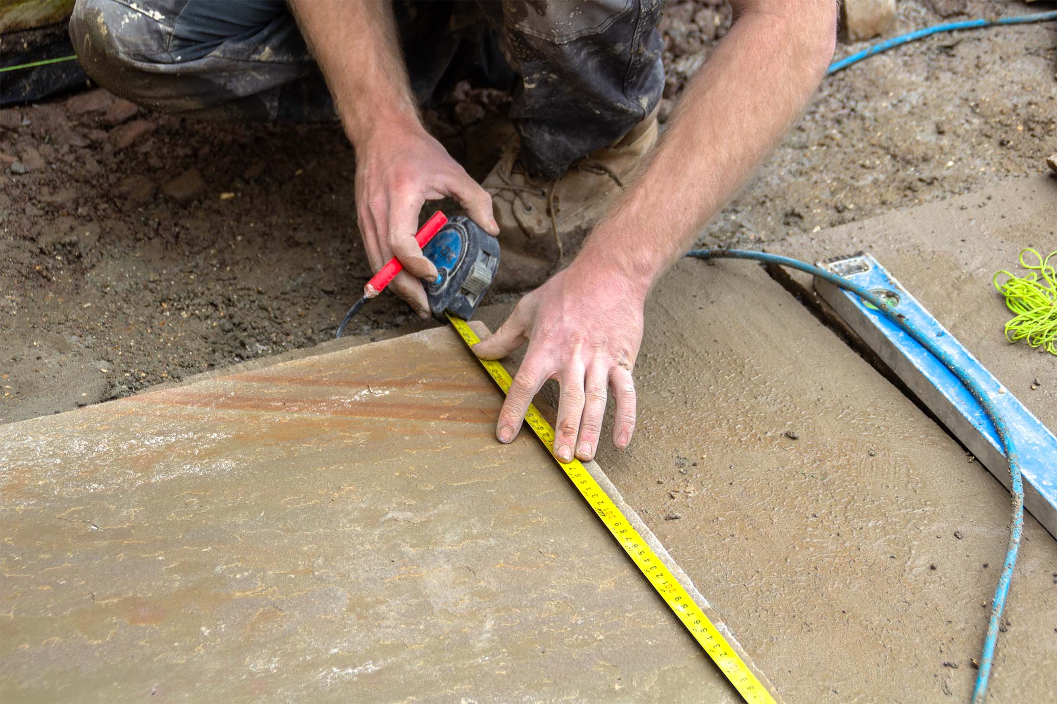 Landscaper measuring paving slabs